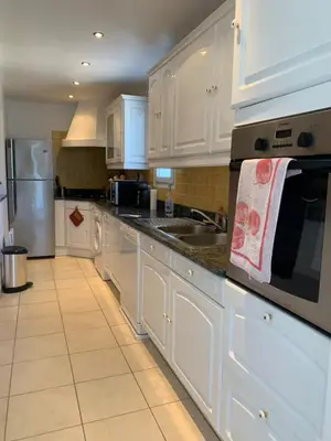 a kitchen with white cabinets and a sink at Casa pace e salute in Olmeta-di-Tuda