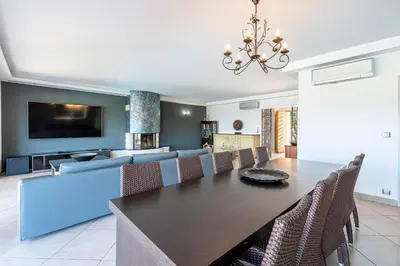 a dining room with a table and a couch at Villa Aigue Marine - Front de mer in Coti-Chiavari