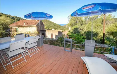a wooden deck with a table and chairs and umbrellas at Amazing Apartment In Partinello in Partinello