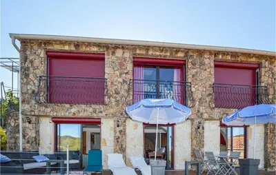 a building with chairs and umbrellas in front of it at Amazing Apartment In Partinello in Partinello