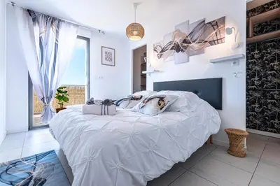 a bedroom with a large bed with two towels on it at Marylanca - PORTICCIO - double terrasse - Wifi - Clim - Parking Privé in Grosseto-Prugna