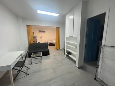 a living room with a couch and a table at Pied-à-terre à 2 pas de la gare d'Ajaccio in Ajaccio
