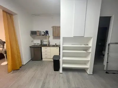a kitchen with a white shelf in a room at Pied-à-terre à 2 pas de la gare d'Ajaccio in Ajaccio
