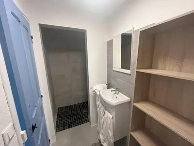 a white bathroom with a sink and a shower at Pied-à-terre à 2 pas de la gare d'Ajaccio in Ajaccio