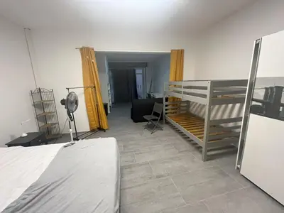 a bedroom with a bed and a desk in a room at Pied-à-terre à 2 pas de la gare d'Ajaccio in Ajaccio