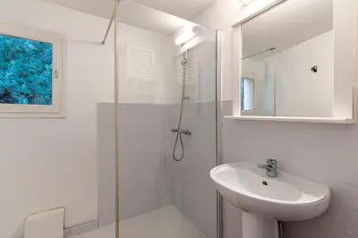 a white bathroom with a sink and a shower at Villa F2 Tonnara pour 4 personnes, Rondinara, Bonifacio in Bonifacio