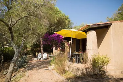a yellow umbrella in front of a house at Villa F2 Tonnara pour 4 personnes, Rondinara, Bonifacio in Bonifacio