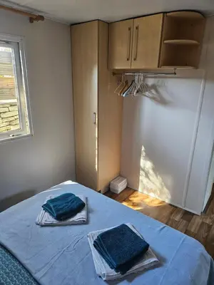 a bedroom with a bed with two towels on it at Logement dans terrain privé et familiale in Bonifacio