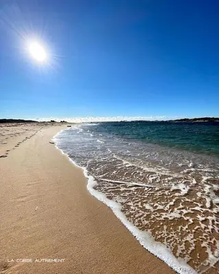 a beach with the ocean and the sun in the sky at Logement dans terrain privé et familiale in Bonifacio