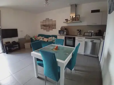 a kitchen and living room with a table and chairs at T3 Bord de mer Agosta plage in Albitreccia