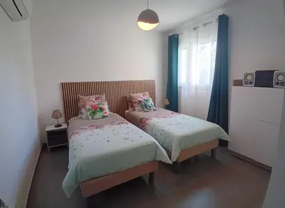 a bedroom with two beds with flowers on them at T3 Bord de mer Agosta plage in Albitreccia