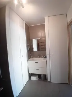 a white bathroom with a sink and a mirror at T3 Bord de mer Agosta plage in Albitreccia