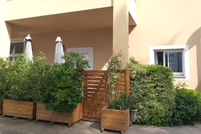 a wooden fence with some plants and an umbrella at T3 Bord de mer Agosta plage in Albitreccia