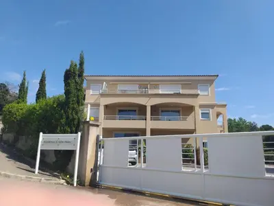a building with a fence in front of it at T3 Bord de mer Agosta plage in Albitreccia