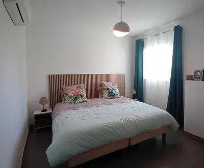 a bedroom with a large bed with flowers on it at T3 Bord de mer Agosta plage in Albitreccia