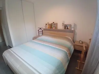 a small bedroom with a bed and a side table at T3 Bord de mer Agosta plage in Albitreccia