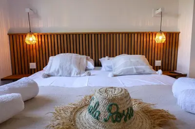 a bedroom with two beds with a straw hat on it at Casetta Mare di Cala Rossa in Cala Rossa