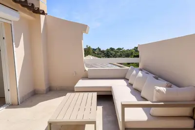 a balcony with a white couch and a wooden bench at Casetta Mare di Cala Rossa in Cala Rossa
