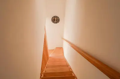 a stairway with a clock on the wall at Casetta Mare di Cala Rossa in Cala Rossa