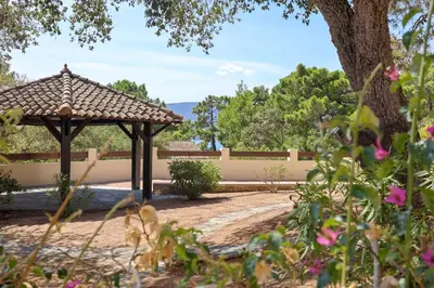 a gazebo in the middle of a garden at Casetta Mare di Cala Rossa in Cala Rossa