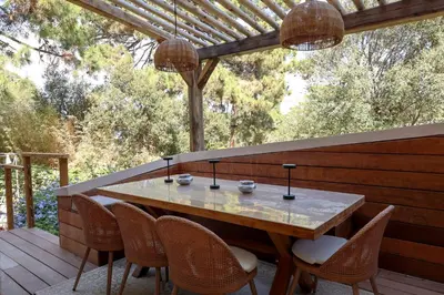 a patio with a table and chairs on a deck at Casetta Mare di Cala Rossa in Cala Rossa