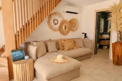 a living room with a couch and a staircase at Casetta Mare di Cala Rossa in Cala Rossa
