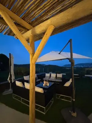 a living room with a table and chairs under a roof at Villa 8 pers vue180 golfe de Porto Vecchio in Porto-Vecchio