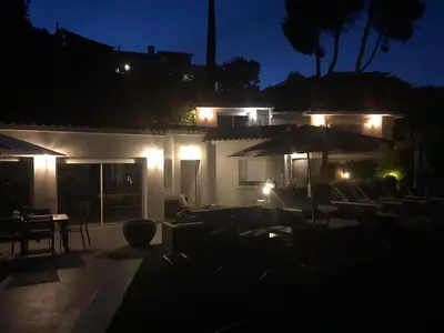 a patio with chairs and umbrellas at night at Villa 8 pers vue180 golfe de Porto Vecchio in Porto-Vecchio