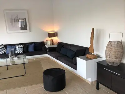 a living room with a black couch and a table at Villa 8 pers vue180 golfe de Porto Vecchio in Porto-Vecchio