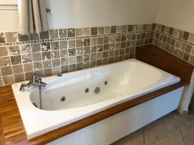 a bath tub with a faucet in a bathroom at Villa 8 pers vue180 golfe de Porto Vecchio in Porto-Vecchio