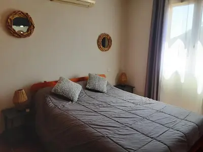 a bedroom with a bed with two pillows and a window at La Palombière - L Arbousier in Casalabriva