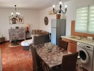 a kitchen and living room with a table and a couch at La Palombière - L Arbousier in Casalabriva