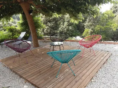 three chairs and a table on a wooden deck at La Palombière - L Arbousier in Casalabriva