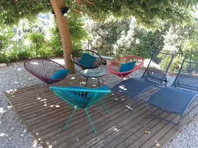 a group of chairs and tables on a wooden deck at La Palombière - L Arbousier in Casalabriva