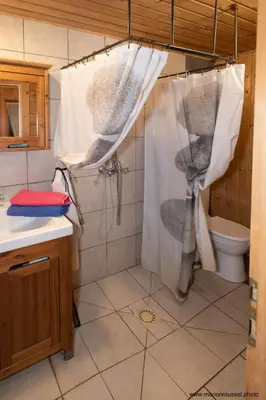 a bathroom with a shower curtain and a toilet at Oliveraie d'Olmiccia in Olmiccia