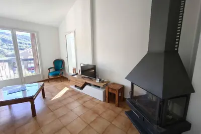 a living room with a fireplace and a table at Bright apartment with two bedrooms in Ajaccio in Cauro