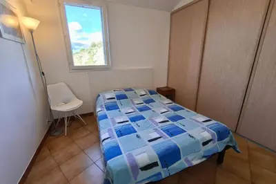 a small bedroom with a bed and a window at Bright apartment with two bedrooms in Ajaccio in Cauro