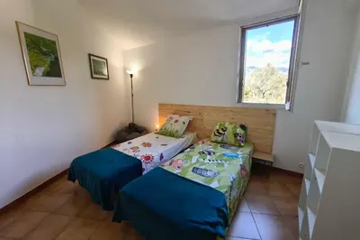 a small bedroom with two beds and a window at Bright apartment with two bedrooms in Ajaccio in Cauro