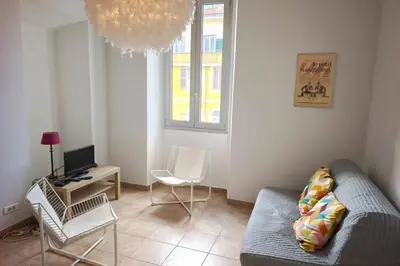 a living room with a couch and a desk with a computer at Bright T3 in the heart of Ajaccio with port view in Ajaccio