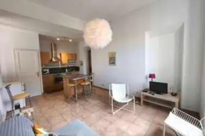 a living room with a table and a dining room at Bright T3 in the heart of Ajaccio with port view in Ajaccio