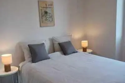 a bedroom with a white bed with two lamps at Bright T3 in the heart of Ajaccio with port view in Ajaccio