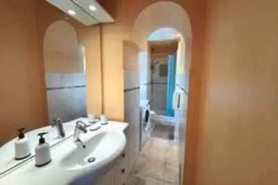 a bathroom with a sink and a mirror and a tub at Bright T3 in the heart of Ajaccio with port view in Ajaccio