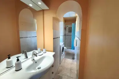 a bathroom with a sink and a mirror and a toilet at Bright T3 in the heart of Ajaccio with port view in Ajaccio
