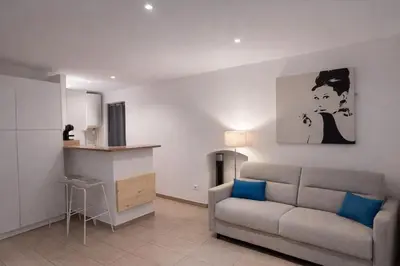 a living room with a couch and a kitchen at Studio vue mer - Centre Ajaccio - 150 m cœur de ville in Ajaccio