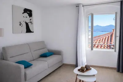 a living room with a couch and a window at Studio vue mer - Centre Ajaccio - 150 m cœur de ville in Ajaccio
