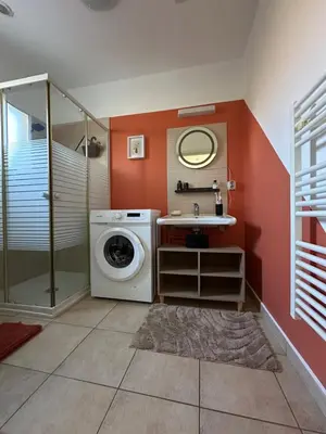 a bathroom with a washing machine and a sink at Mini villa residence 3 étoiles Cervione in Cervione