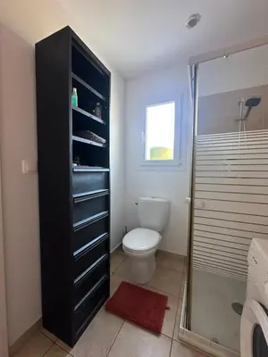 a bathroom with a toilet and a glass shower at Mini villa residence 3 étoiles Cervione in Cervione