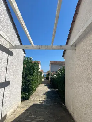 an alley between two walls with a blue sky at Mini villa residence 3 étoiles Cervione in Cervione