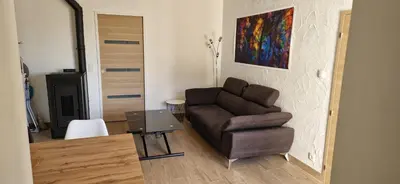a living room with a chair and a table at Maison a Porto Pollo Corse du sud in Serra-di-Ferro
