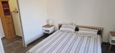 a bedroom with two beds and a lamp on a table at Maison a Porto Pollo Corse du sud in Serra-di-Ferro